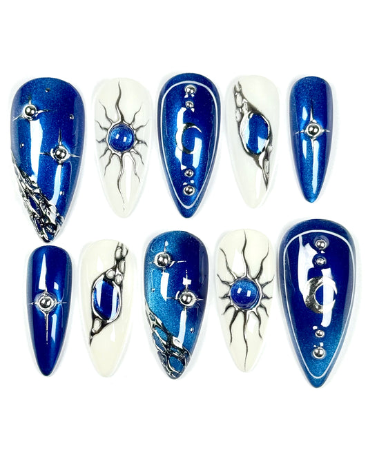 Set de press-on nails inspiré d’Unfair tome 1. Design argenté, reflets lunaires et esthétique mystique. Création artisanale Kapsule Nails.